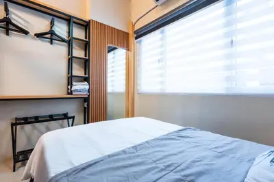a bedroom with a bed and a large window at Shell Residences Pasay 1BR Walk to MOA Newly Renovated! in Manila