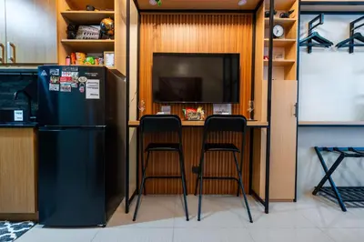 a kitchen with a bar with two stools and a tv at Shell Residences Pasay 1BR Walk to MOA Newly Renovated! in Manila