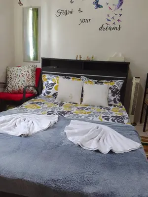 a bed with a blue comforter and pillows on it at Aliyahs Place in Cainta