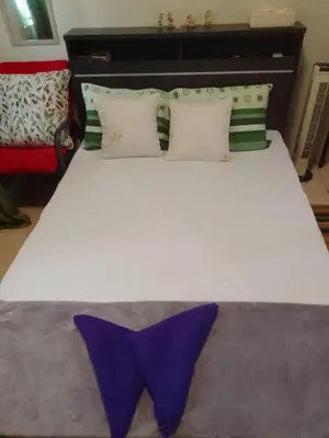 a bed with two purple pillows on top of it at Aliyahs Place in Cainta