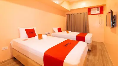 two beds in a room with red and white at RedDoorz Plus @ Kaizen Suites Taft Avenue in Manila