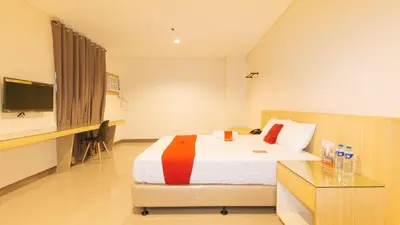 a bedroom with a bed and a desk and a television at RedDoorz Plus @ Kaizen Suites Taft Avenue in Manila