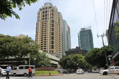 a city with tall buildings and cars on a street at Mosaic Tower in Manila