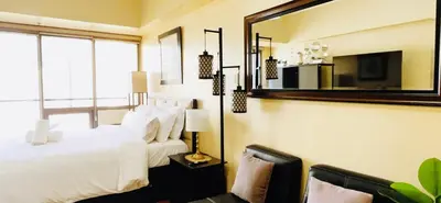 a bedroom with a white bed and a mirror at Mosaic Tower in Manila