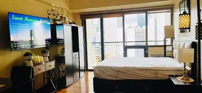 a bedroom with a bed and a flat screen tv at Mosaic Tower in Manila