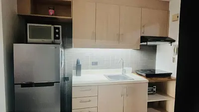 a kitchen with a refrigerator and a sink at Mosaic Tower in Manila