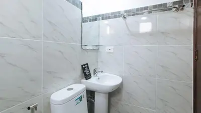 a white bathroom with a sink and a toilet at RedDoorz near UST Sampaloc Manila in Manila