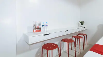a bedroom with two red stools under a white counter at RedDoorz near UST Sampaloc Manila in Manila