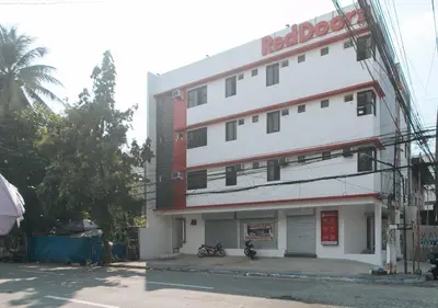 a white building with a redodo sign on it at RedDoorz near UST Sampaloc Manila in Manila