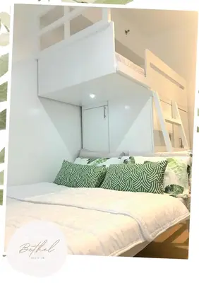 a bed with green and white pillows in a room at Bethel House in Manila