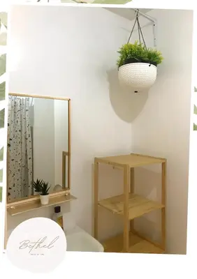 a bathroom with a mirror and a toilet and a shelf at Bethel House in Manila