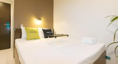 a white bed in a room with a table on it at UrbanView at San Antonios Place Sampaloc Manila in Manila