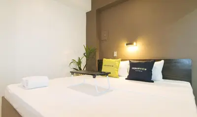 a white bed with pillows and a table on it at UrbanView at San Antonios Place Sampaloc Manila in Manila