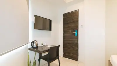 a small room with a desk and a television on a wall at UrbanView at San Antonios Place Sampaloc Manila in Manila