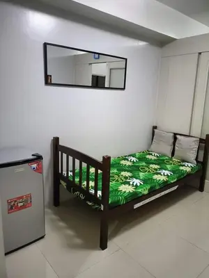 a bedroom with a bed and a mirror on the wall at Blue's Residences in Manila