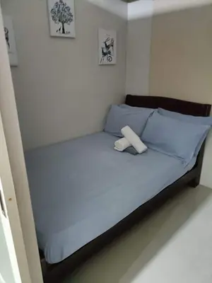 a bed with two towels on it in a room at Blue's Residences in Manila