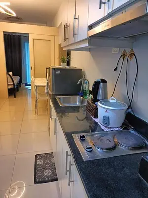 a kitchen with a stove and a sink and a counter top at Blue's Residences in Manila
