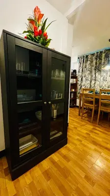 a black cabinet with a flower on top of it at Modern Condotel Stay with Netflix, Kitchen & Washer, Near MRT Boni in Manila