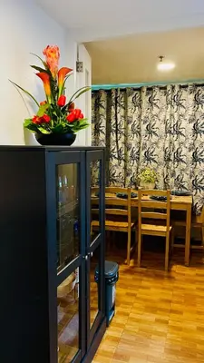 a dining room with a table and a vase of flowers at Modern Condotel Stay with Netflix, Kitchen & Washer, Near MRT Boni in Manila