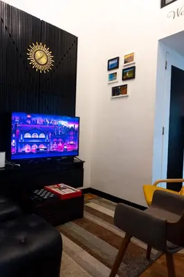 a living room with a flat screen tv on a table at Modern Condotel Stay with Netflix, Kitchen & Washer, Near MRT Boni in Manila