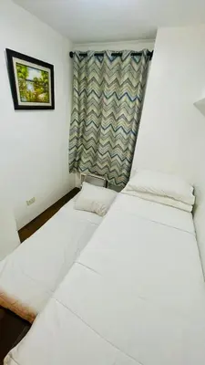 two beds in a room with a window at Modern Condotel Stay with Netflix, Kitchen & Washer, Near MRT Boni in Manila