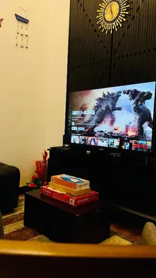 a pile of books sitting in front of a tv at Modern Condotel Stay with Netflix, Kitchen & Washer, Near MRT Boni in Manila