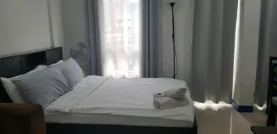 a bedroom with a white bed with a towel on it at Innsite Room Rentals in Manila