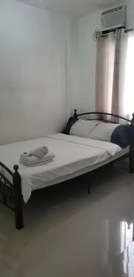 a bed sitting in a room with a window at Innsite Room Rentals in Manila