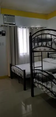 two bunk beds in a room with a window at Innsite Room Rentals in Manila