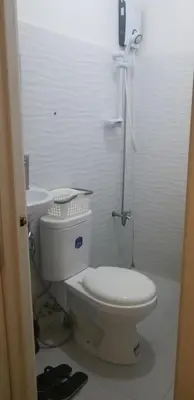 a white bathroom with a toilet and a sink at Innsite Room Rentals in Manila
