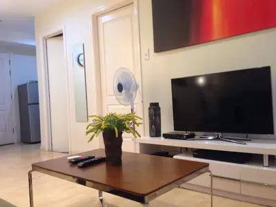 a living room with a tv and a coffee table at 1 Bedroom with balcony Near Airport Bgc Taguig City in Manila
