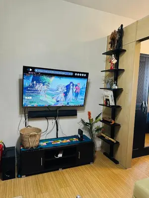 a living room with a flat screen tv on a wall at 1 Bedroom with balcony Near Airport Bgc Taguig City in Manila