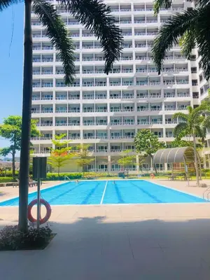 a swimming pool in front of a large building at 1 Bedroom with balcony Near Airport Bgc Taguig City in Manila