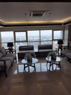 a living room with couches and tables and windows at Schönes Apartment mit Pool-Nutzung in Manila