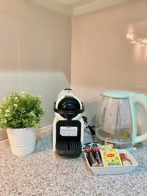 a coffee maker sitting on a counter next to a bowl of food at 1BR executive unit in Uptown Parksuites BGC in Manila