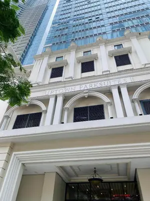 a building in front of a tall skyscraper at 1BR executive unit in Uptown Parksuites BGC in Manila