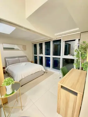 a bedroom with a bed and a large window at 1BR executive unit in Uptown Parksuites BGC in Manila