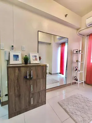 a room with a large mirror and a dresser with a dresser at Coast Residences, Roxas Blvd, Pasay City in Manila