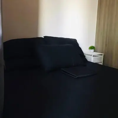 a bed with black sheets and a black blanket at Cozy Bedroom FAME Condo Greenfield EDSA MRT Shaw in Manila