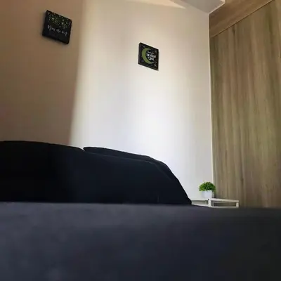 a bedroom with a bed with two clocks on the wall at Cozy Bedroom FAME Condo Greenfield EDSA MRT Shaw in Manila
