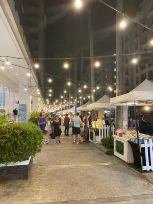 a group of people walking around a market at night at S&S CondoTel STUDIO TYPE One Palm Tree Villas in Manila