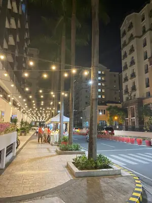 a city street at night with palm trees and buildings at S&S CondoTel STUDIO TYPE One Palm Tree Villas in Manila