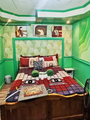 a bedroom with a bed in a green room at City Tower Condominium Transient Inn in Manila