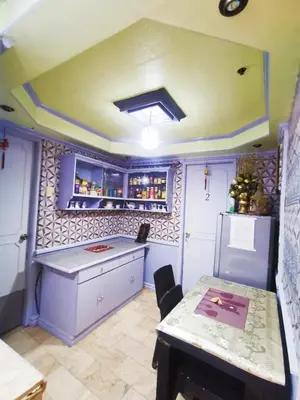 a kitchen with a counter and a table and a refrigerator at City Tower Condominium Transient Inn in Manila