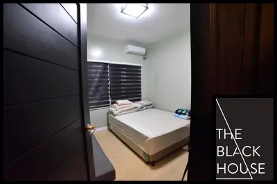 a small bedroom with a bed and a black house at The Black House in Dulong Bayan