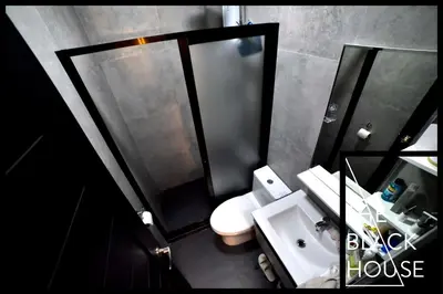 a bathroom with a shower and a toilet and a sink at The Black House in Dulong Bayan