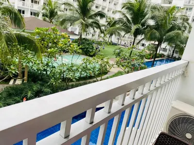 a balcony of a resort with a pool and palm trees at SHORE RESIDENCE D4 shortwalk MALL OF ASIA NEAR AIRPORT in Manila