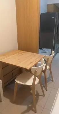 a wooden table with two white chairs around it at SHELL RESIDENCE C1 shortwalk MALL OF ASIA NEAR AIRPORT in Manila