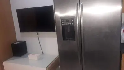 a stainless steel refrigerator with a television on top of a counter at SHELL RESIDENCE C1 shortwalk MALL OF ASIA NEAR AIRPORT in Manila