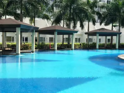 a large pool with blue water in front of a building at MOA CONDOTEL MANILA in Manila